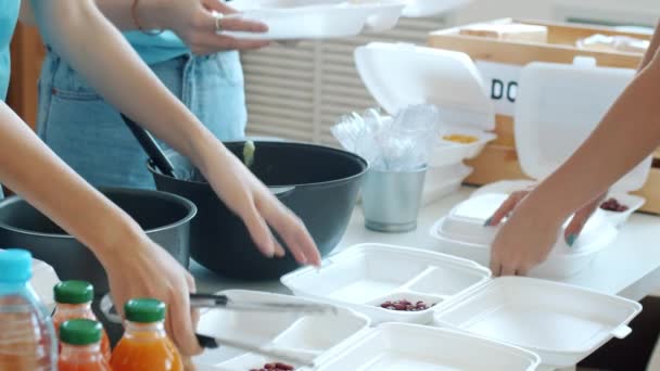 Close Mãos Voluntários Colocando Alimentos Lancheiras Alimentando Pobres Organização Caridade — Vídeo de Stock