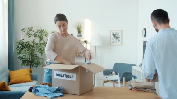 Man Woman Packing Clothes Donation Box Home Child Bringing Teddy — Stock Video