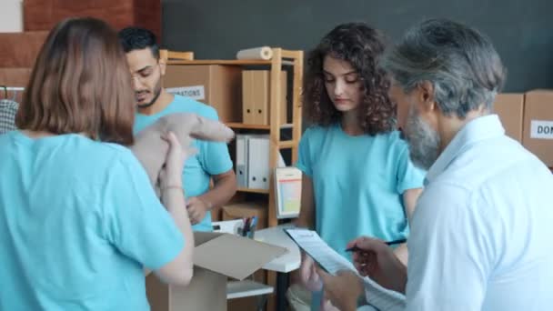 Grupo Voluntarios Preparando Cajas Ropa Para Donación Luego Haciendo Chocar — Vídeo de stock