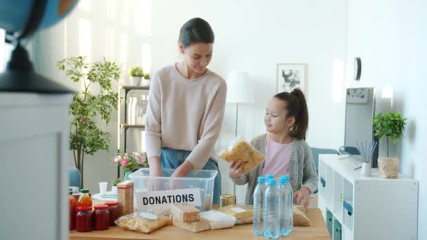 Mutter Und Tochter Packen Lebensmittel Gegen Eine Spende Ein Während — Stockvideo