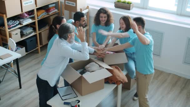 一群身穿制服的志愿者手拉手 高举5个手势 在慈善基金办公室享受合作 团队精神和志愿精神概念 — 图库视频影像