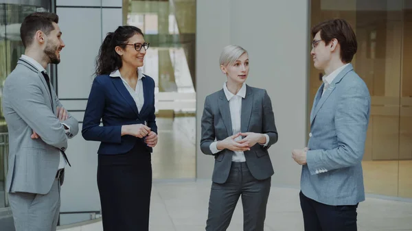 Mulher Negócios Conversando Com Seus Colegas Enquanto Estava Lobby Escritório — Fotografia de Stock