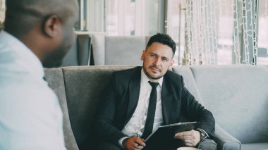 Afro-Amerikan adamla röportaj iş olan ve modern kafe kapalı onun özgeçmiş uygulamasında izlerken insan kaynakları iş adamı
