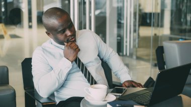 Diz üstü seyir ve onun iş planı camsı kafede üzerinde öğle yemeği molası sırasında düşünme formal giyim Afrika Americanbusinessman. O düşünceli ve proje fikirleri hakkında düşünme..