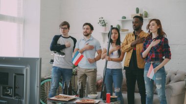 Arkadaşlar çok etnik grup spor dinleme ve TV Spor şampiyonluk birlikte evde kapalı izlemeden önce Hollanda milli marşı şarkı hayranları