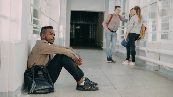 Вид Расстроенного Африканско Американского Студента Сидящего Полу Белом Просторном Университете — стоковое фото