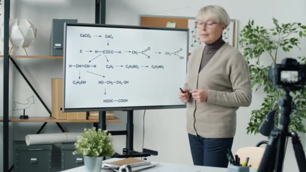 有经验的化学老师用摄像机为科学博客录音教学 使用数字屏幕显示公式和说话的成熟女人 — 图库视频影像