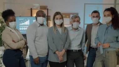Gece iş yerinde maske takan iş adamları ve iş kadınlarının portresi. Karantina ve profesyonel işgal kavramı.