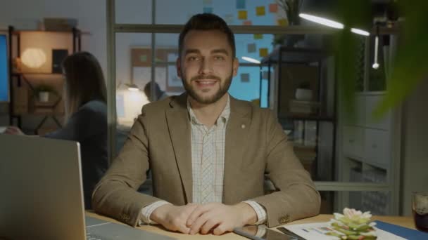 Повільний Портрет Щасливого Молодого Підприємця Який Сидить Офісі Ввечері Посміхаючись — стокове відео