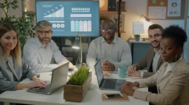 Ofiste oturmuş kameraya gülümseyen başarılı bir iş adamının yavaş çekim portresi. Meslek mesleği ve kariyer kavramı.