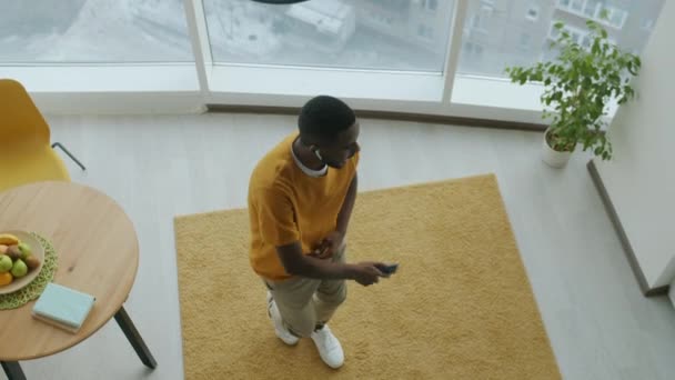 Вид Сверху Счастливого Афроамериканца Танцующего Современной Кухне Наслаждаясь Музыкой Смартфона — стоковое видео