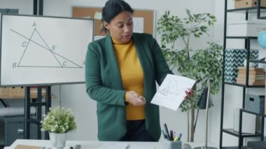 Kolej öğretmeni covid-19 karantina karantinası sayesinde matematik öğretiyor ve sınıfın içindeki kameralara bakıyor. Halk ve eğitim kavramı.