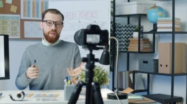 İngilizce öğretmeni bilgisayar ekranına işaret eden gramer ve çevrimiçi vlog için kamera ile kayıt dersi açıklıyor. Modern teknoloji ve eğitim kavramı.
