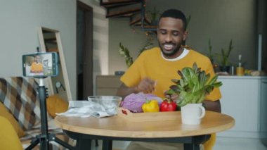 Mutfaktaki modern akıllı telefon kamerasını kullanarak sebzeleri beşlik çakarken gösteren video kaydı.