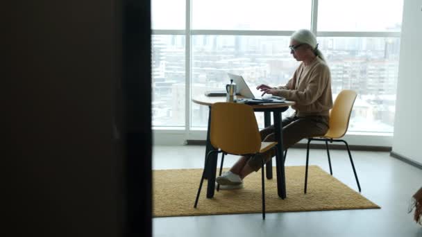 Серьезный Бизнесмен Работающая Дома Используя Ноутбук Печатающий Кухонным Столом Современные — стоковое видео