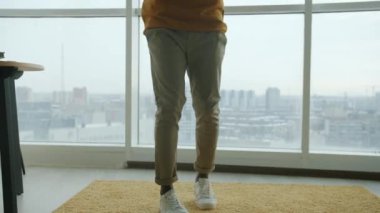 Yavaş çekimde, kulaklık takan mutlu öğrencinin akıllı telefon tutarak dans edişinin portresi. Modern yaşam tarzı ve teknoloji kavramı.