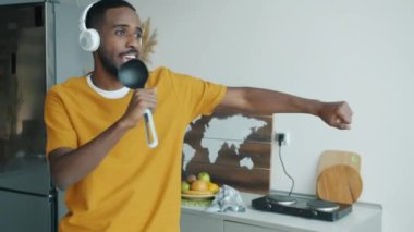 Kaşıkla şarkı söyleyerek, kulaklıkla müzik dinleyerek ve mutfakta dans ederek geçen eğlenceli bir milenyum. Boş zaman ve eğlence konsepti.