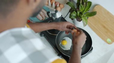 Erkek eller yemek pişirirken yumurta ve pastırma pişirirken evde elektrikli fırın kullanırken. Aşçılık ve yaşam tarzı kavramı.