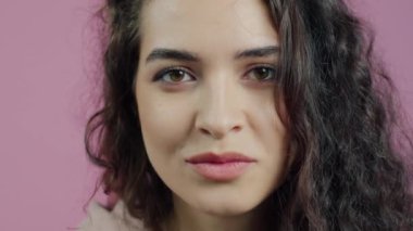 Komik suratlar yapan, gülümseyen pembe arka planda kameraya bakarken eğlenen neşeli kızın yakın plan portresi. Milenyum ve duygu konsepti.