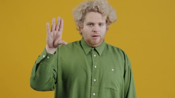 Портрет Раздраженного Человека Делающего Жест Руки Шевелящегося Рта Стоящего Желтом — стоковое видео
