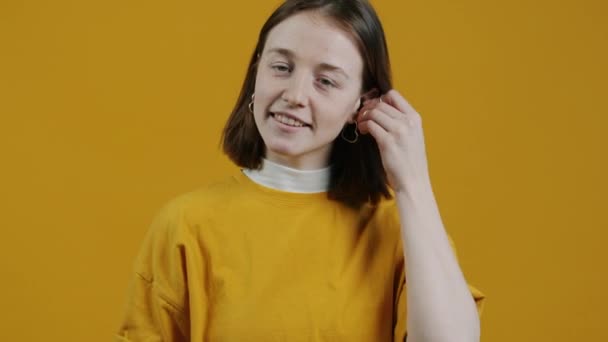 Portrét Moderní Dívky Používající Sluchátka Kývající Hlavu Tančící Žlutém Pozadí — Stock video