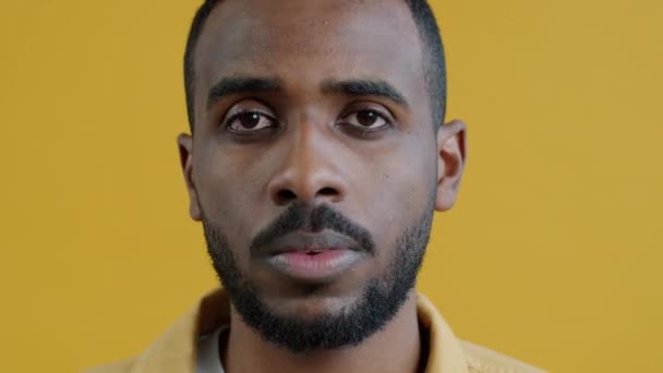 这张特写是一个不快乐的非裔美国人在拍摄枪枝自杀姿势 并在黄色背景下看着相机的特写 人与情感概念 — 图库视频影像