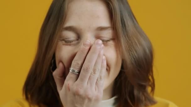노란색 배경의 카메라를 매력적 여성의 표정의 — 비디오