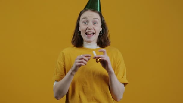 Портрет Веселой Девушки Праздничной Шляпе Дующей Рог Хлопающей Ладоши Жёлтом — стоковое видео