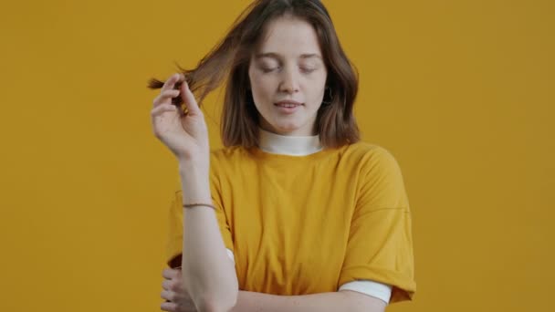Медленный Портрет Женщины Улыбающейся Играющей Волосами Желтом Фоне Обаятельные Люди — стоковое видео
