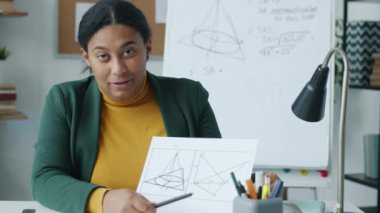 İnternette geometri öğreten Afrikalı Amerikalı bir kadının portresi. Konuşuyor ve ofis kameralarına bakıyor. Eğitim ve sosyal uzaklık kavramı.