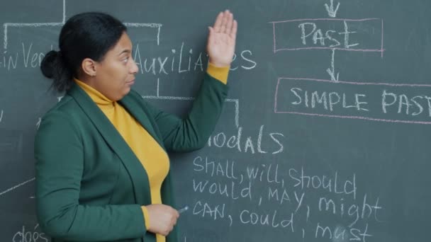 온라인으로 영어를 가르치고 교실에서 칠판을 가리키며 설명하는 교사의 초상화 — 비디오
