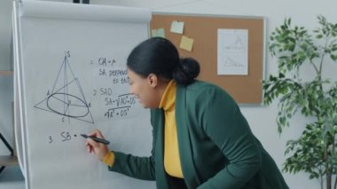 Kolej öğretmeni kameraya bakarak uçakta covid-19 pandemik yazı yazarken çevrimiçi ders veriyor. Uzak eğitim ve salgın konsepti.