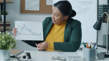 Kadın matematik öğretmeni, internet dersi sırasında teoriyi anlatıyor ve sınıfta el sallıyor. Bilim ve çevrimiçi eğitim kavramı.