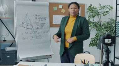 İçerideki modern kamerayı kullanarak, oyun konsoluna bakan çevrimiçi video bloğu için matematik hocası video kaydı. Vlog yazma ve İnternet eğitimi kavramı.