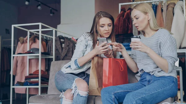 Aantrekkelijke Jonge Dames Zitten Stoelen Een Kledingwinkel Met Koffie Boodschappentassen — Stockfoto