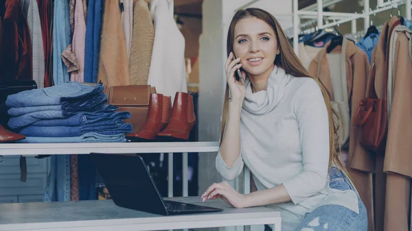 Jonge Zakenvrouw Werken Met Laptop Vrolijk Praten Haar Mobiele Telefoon — Stockfoto