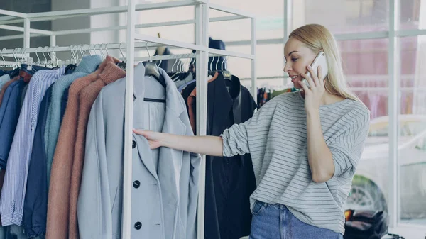 Sevimli Sarışın Kız Modern Butik Akıllı Telefon Sohbet Elbise Askıları — Stok fotoğraf