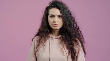 Pembe arka planda hayır anlamına gelen kollarını açmış güzel genç bir kadının portresi. İnkar ve hayal kırıklığı kavramı.