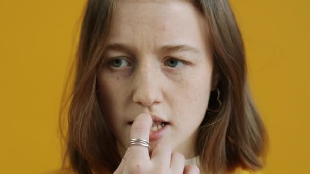 Portret Nerwowej Dziewczyny Obgryzającej Paznokcie Patrzącej Kamerę Żółtym Tle Koncepcja — Wideo stockowe