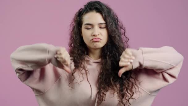 Ontevreden Jonge Vrouw Toont Duimen Hand Gebaar Fronsen Roze Achtergrond — Stockvideo