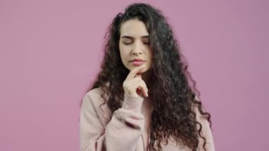 Kamerayı işaret eden neşeli genç bayan portresi ve pembe arka planda el sallayan parmak. Duygular ve ifadeler kavramı.