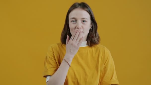 노란색 배경에 키스와 미소를 보내는 아름다운 아가씨의 움직임 연애와 표현의 — 비디오