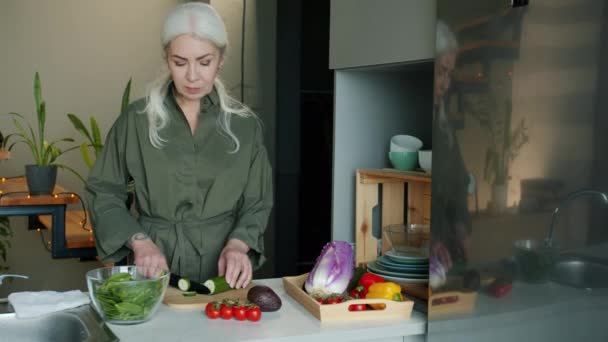 Πορτρέτο Της Ώριμης Κυρίας Μαγείρεμα Λαχανικών Σαλάτα Τεμαχισμό Αγγούρι Μαχαίρι — Αρχείο Βίντεο
