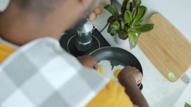 Genç bir adamın evde pişirdiği nefis kahvaltı pastırması ve yumurtaların üstünden. Beslenme ve mutfak aletleri konsepti.
