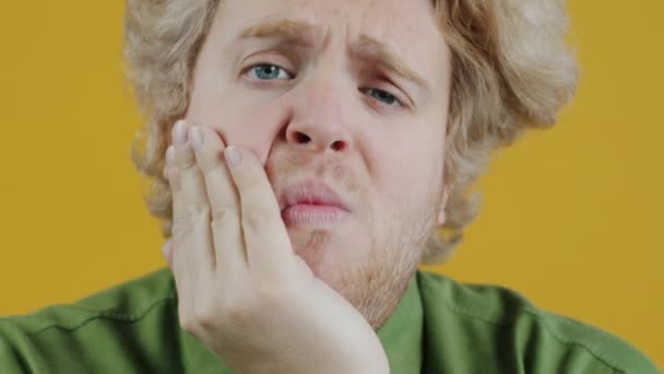 Sarı Arka Planda Diş Ağrısı Hisseden Üzgün Yüzüyle Kameraya Bakan — Stok video