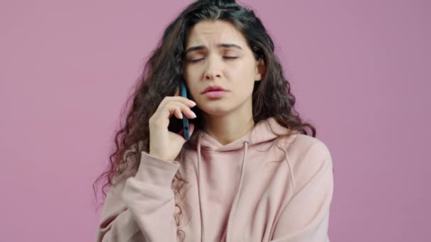 Sinirli Genç Bir Kadın Cep Telefonuyla Konuşuyor Pembe Arka Planda — Stok video
