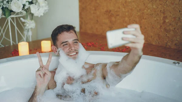 Przystojny Facet Wesoły Jest Biorąc Selfie Wannie Mydła Pianki Brodę — Zdjęcie stockowe