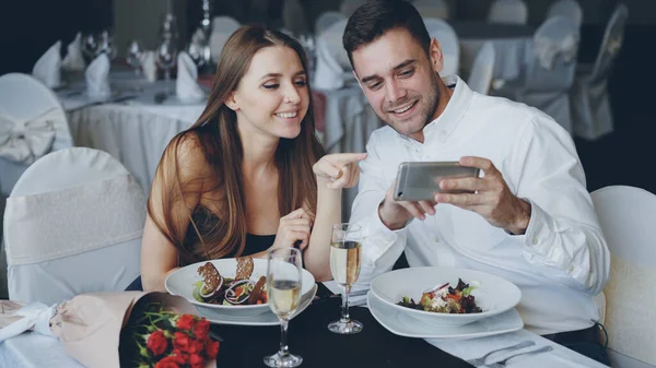 Los Jóvenes Felices Atractivos Están Viendo Smartphone Juntos Sonriendo Hablando —  Fotos de Stock