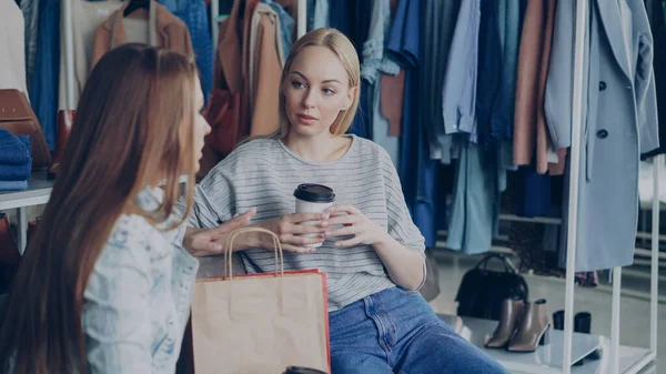 Jonge Aantrekkelijke Vrouw Zitten Moderne Kleding Winkel Holding Van Koffie — Stockfoto