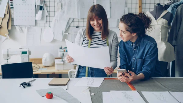 Привлекательные Молодые Женщины Работающие Дизайнерской Индустрии Сравнивают Эскизы Говорят Работая — стоковое фото